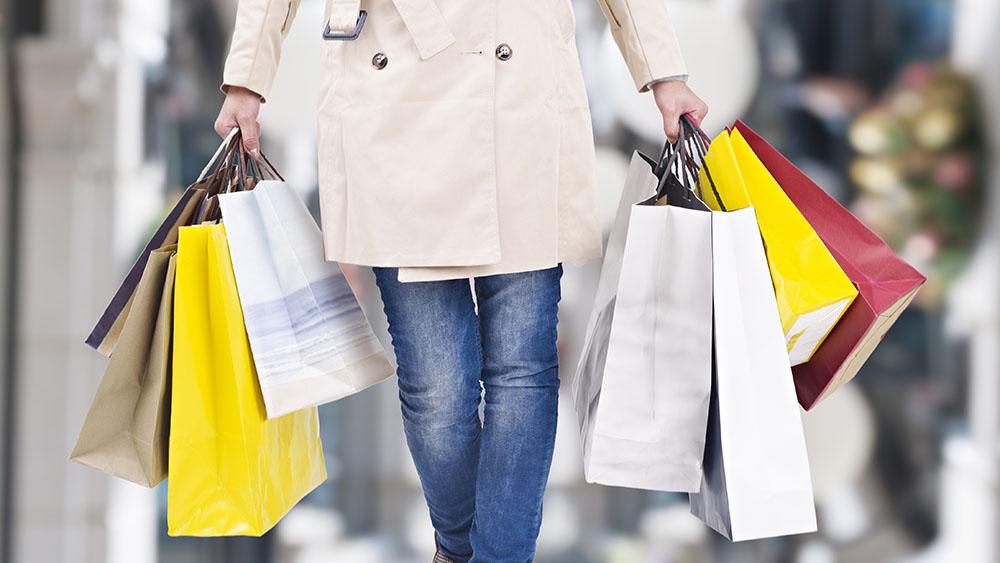 Kvinna med många shoppingkassar i händerna.